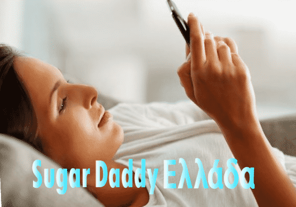 Το κορίτσι κοιτάζει το κινητό τηλέφωνο στο κρεβάτι